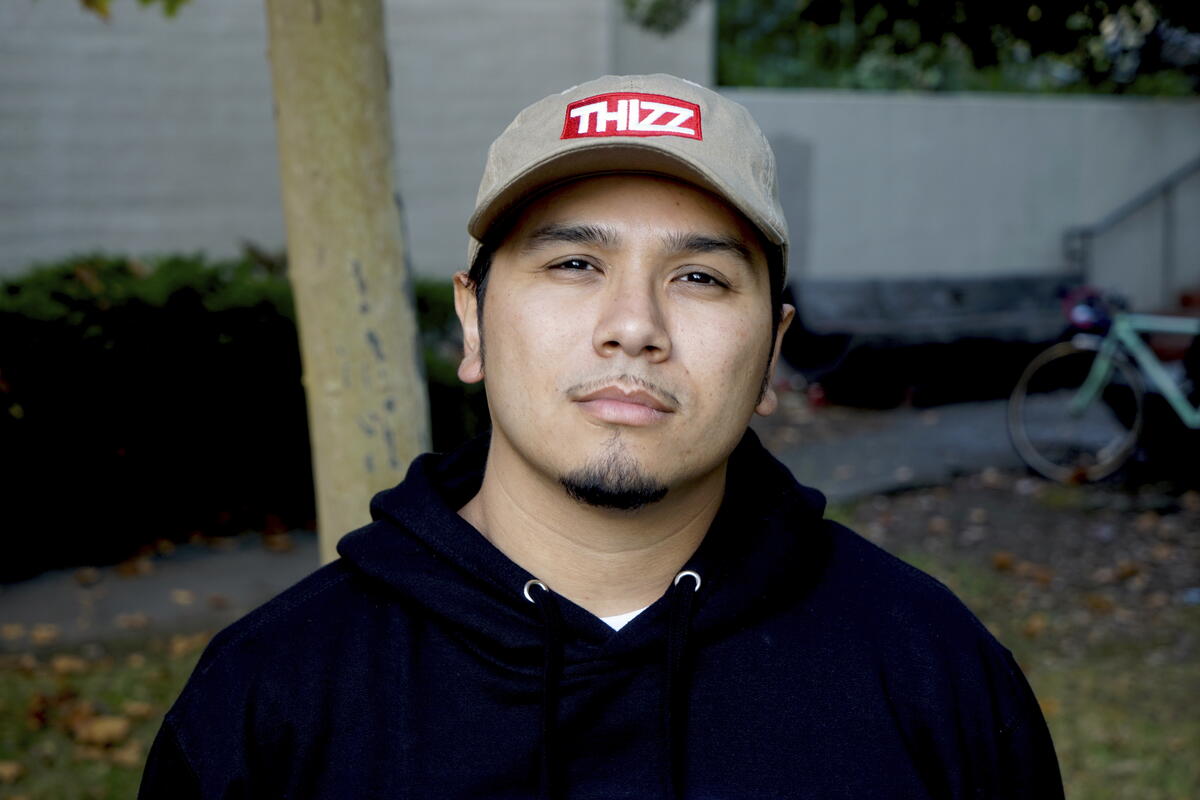 Headshot of Robin López, serious expression, wearing black hoodie and beige hat with logo "THIZZ"